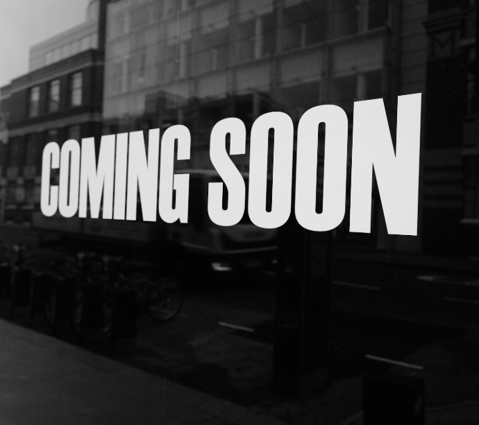 a black and white photo of a sign that says coming soon