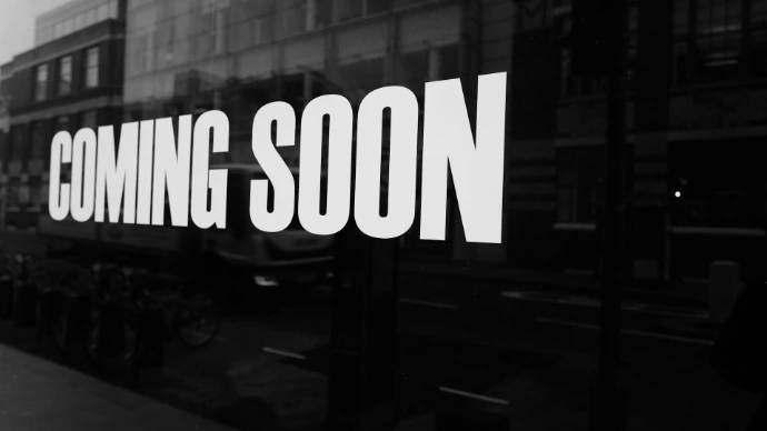 a black and white photo of a sign that says coming soon